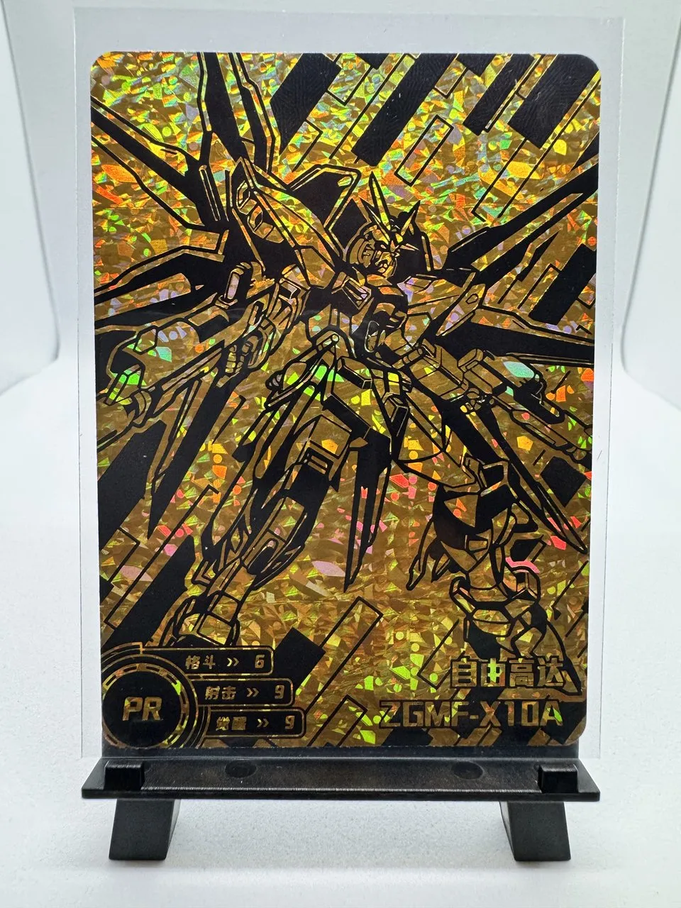 A gold cracked-ice holographic promo card of the ZGMF-X10A Freedom Gundam from little frog's Mechanical Story doujin set