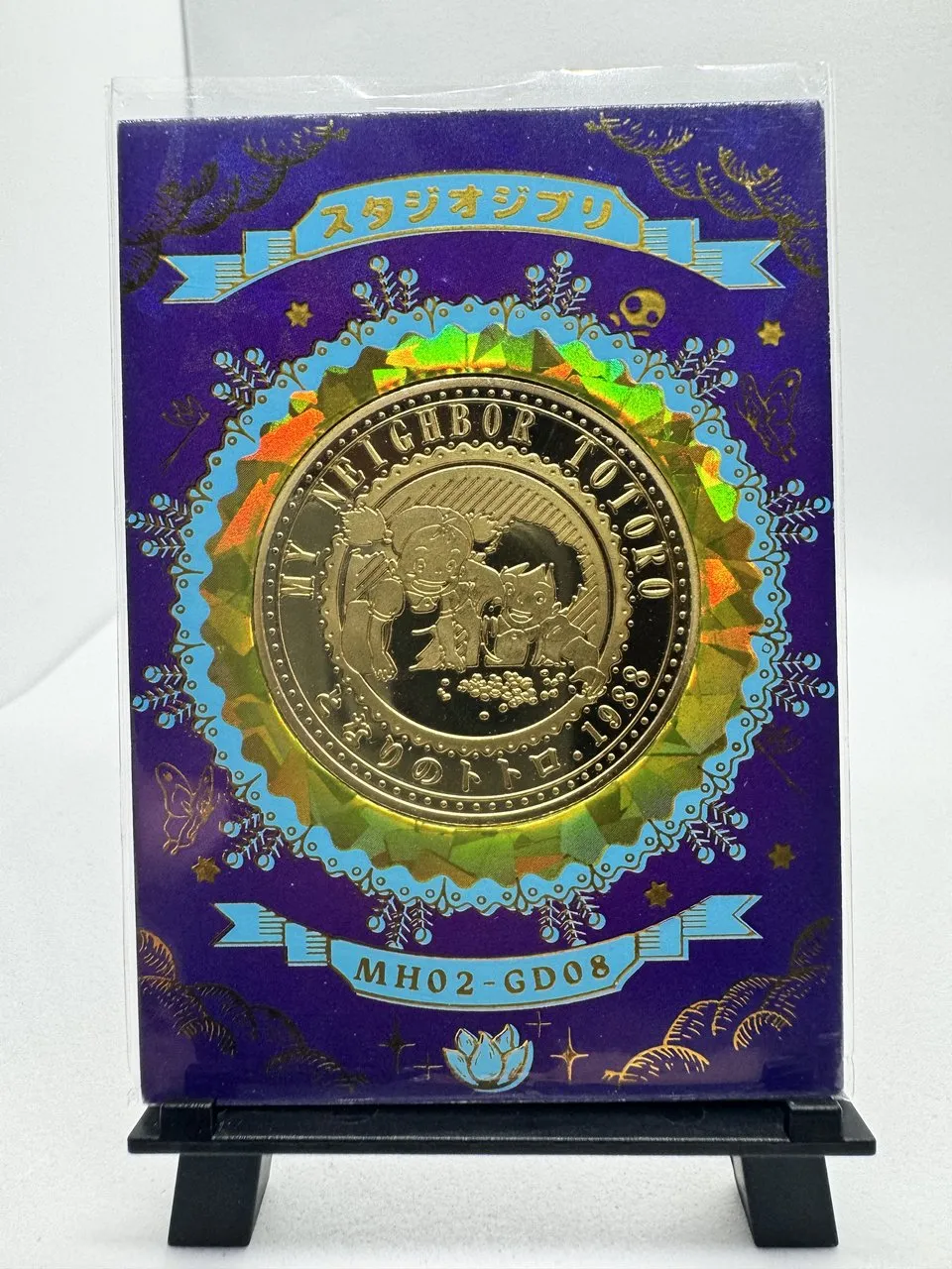 A purple holographic My Neighbor Totoro card with an embedded gold medallion of Totoro and the soot sprites, serial 040/188