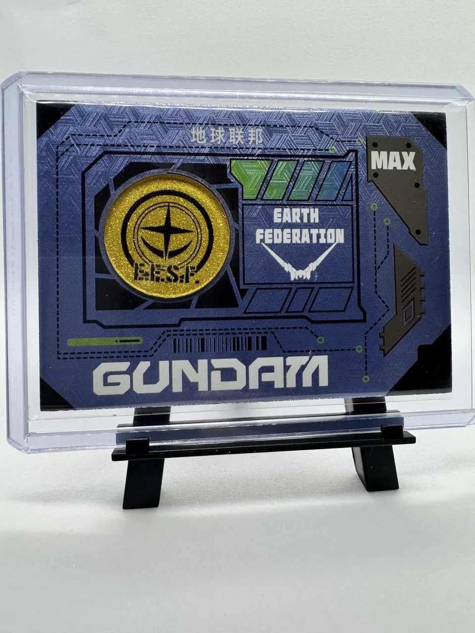 A blue Gundam card with an embedded gold-colored E.F.S.F. coin, MAX rarity, serialized to 111 copies